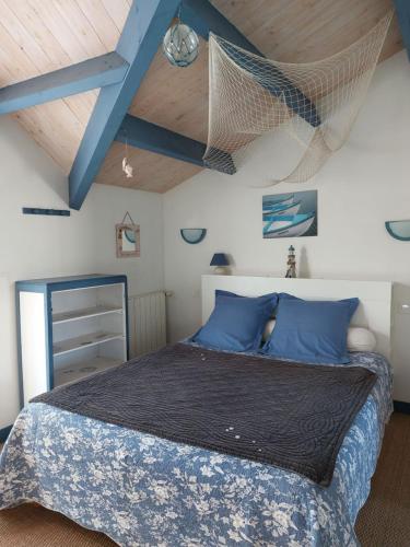 a bedroom with a bed with a net on the ceiling at La Villa Vert Marine in Châtelaillon-Plage