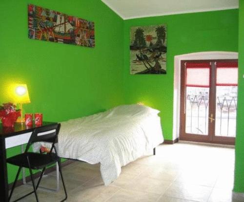 Habitación verde con cama y escritorio. en B&B Piazza Vittorio, en Turín