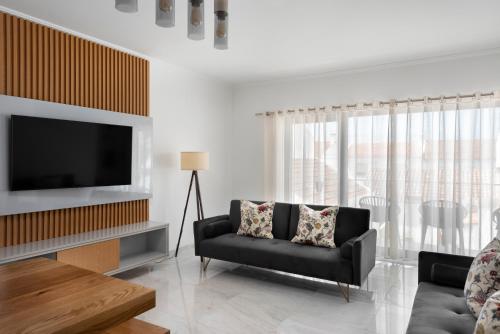 a living room with a couch and a television at Lazy Days - Adults Only - Duna Parque Resorts & Hotels in Vila Nova de Milfontes