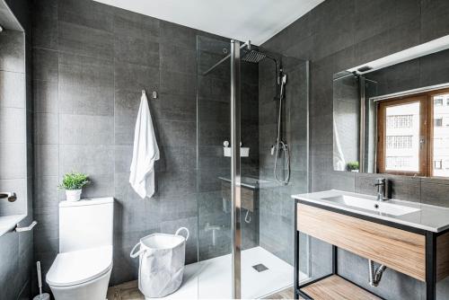 een badkamer met een douche, een toilet en een wastafel bij Ronces Hostel in Pamplona