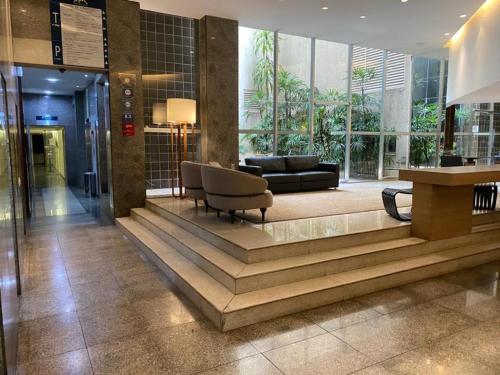a lobby with a couch and a table in a building at Max Savassi Glamour in Belo Horizonte
