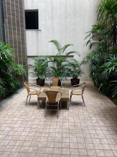 a patio with a table and chairs and plants at Max Savassi Glamour in Belo Horizonte