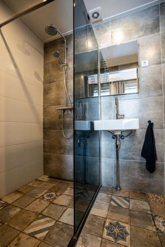 a bathroom with a sink and a shower at The Hogg House - a city delight for two in Groningen