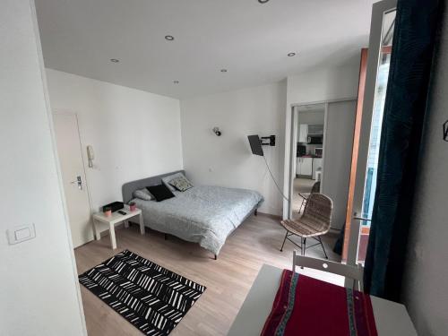 une petite chambre avec un lit et une chaise dans l'établissement Appartement Cosy centre ville Aix les bains (Cures et courts sejours), à Aix-les-Bains