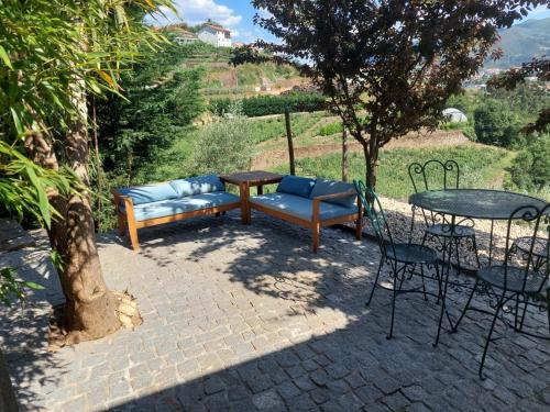 a patio with a couch and a table and chairs at Quinta São José - Museu do Triciclo in Mesão Frio