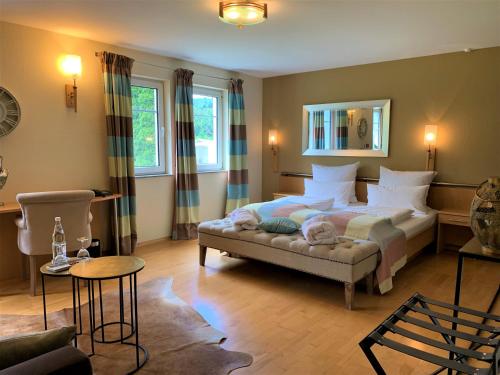 a bedroom with a bed and a couch in a room at Das Landhaus Apartments in Prüm