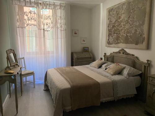 ein Schlafzimmer mit einem Bett, einer Kommode und einem Fenster in der Unterkunft Violetta Maison, elegante e romantica a Salo’ in Salò