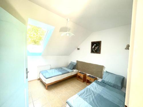 a bedroom with two beds and a window at Molnarhouse in Kápolnásnyék