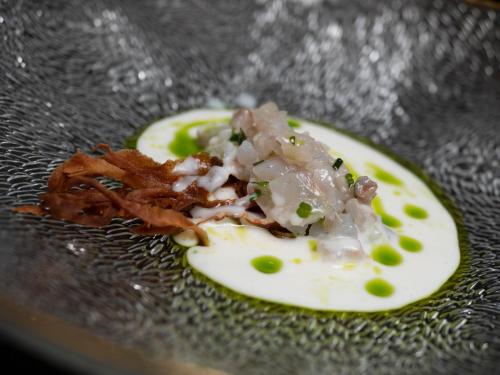 a plate of food with onions and bacon on it at Vivid Blue Serenity Resort in Sveti Stefan