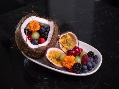 a plate of fruit on a black table at Vivid Blue Serenity Resort in Sveti Stefan