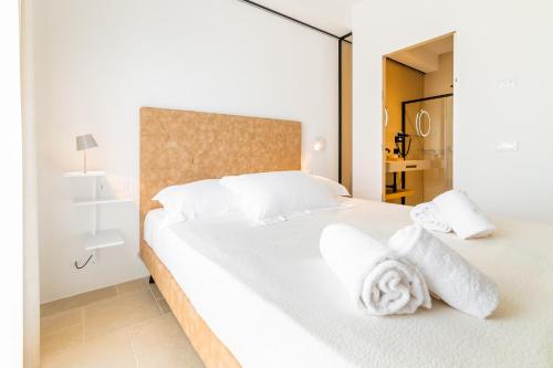 a bedroom with a large white bed with towels on it at B&B A C-Caste in Monopoli