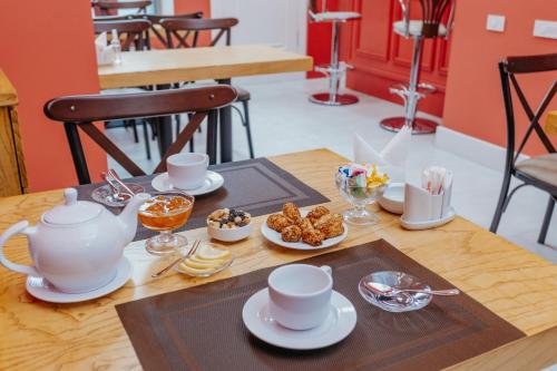 巴庫的住宿－Callisto Hotel，茶壶,茶杯和食物的桌子