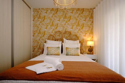 a bedroom with a bed with two towels on it at Resort Holidays Nazaré in Nazaré