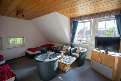 a living room with couches chairs and a television at Gästehaus Wedework in Wedemark