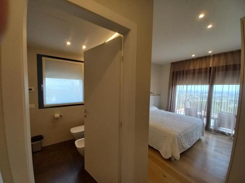 1 dormitorio con cama, aseo y ventana en TERRAZZA SAN VETTORE, en Maser