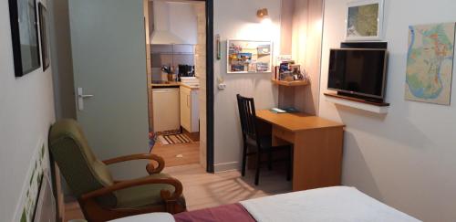 une petite chambre avec un petit bureau et une cuisine dans l'établissement Locations IDEALOGIS Studios et T2 avec WIFI LAVERIE VELOS, à Rochefort