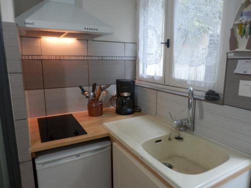 une petite cuisine avec un évier et un comptoir dans l'établissement Locations IDEALOGIS Studios et T2 avec WIFI LAVERIE VELOS, à Rochefort
