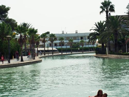 two people swimming in a pool in a body of water at Venecia Apartments in Port d'Alcudia