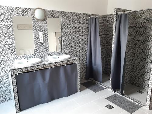 Baño con 2 lavabos y espejo en 20 Bakancs Apartman en Esztergom