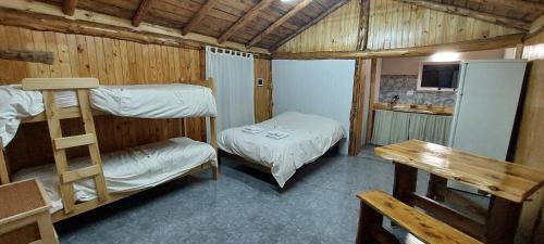 una habitación con dos literas y una nevera en El Cipresal- Pichi Ruka, en San Martín de los Andes