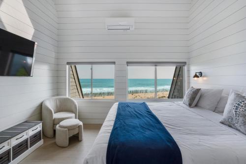 a bedroom with a bed and a view of the ocean at The Surf Club Resort in Montauk