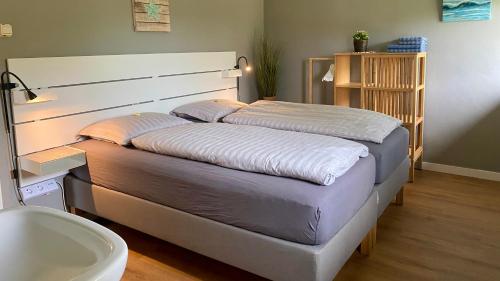Een bed of bedden in een kamer bij Vakantiehuis De Branding, slechts 2 minuten van Strand en Zee!