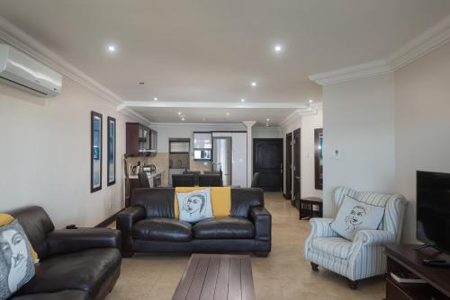a living room with a leather couch and two chairs at Ballito Manor View 503 - With Generator in Ballito
