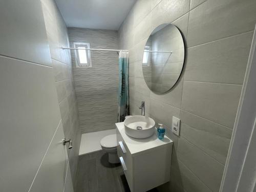 a white bathroom with a sink and a mirror at Apartamento Conil Playa in Conil de la Frontera