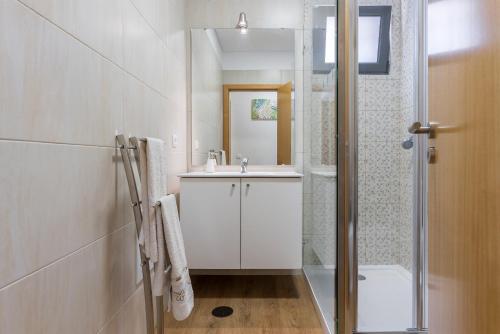 a white bathroom with a sink and a shower at Villa Teresa by Atlantic Holiday in São Vicente