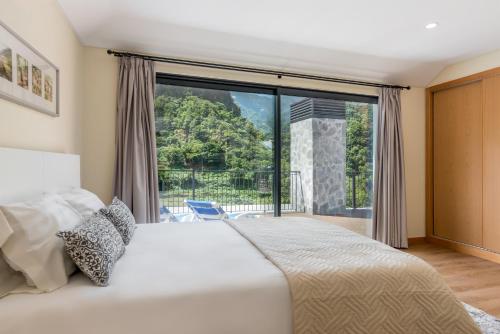 a bedroom with a bed and a large window at Villa Teresa by Atlantic Holiday in São Vicente