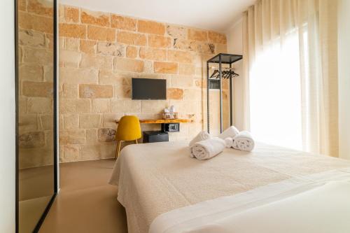 a bedroom with a bed with towels on it at B&B A C-Caste in Monopoli