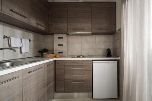 a kitchen with wooden cabinets and a sink at Tsamakdas House in Toroni