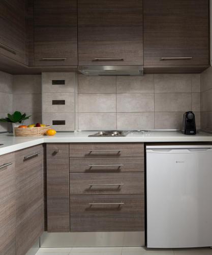 a kitchen with wooden cabinets and a white refrigerator at Tsamakdas House in Toroni