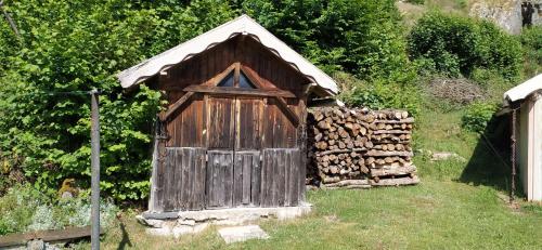 - un petit bâtiment en bois avec une pile de bois pour le feu dans l'établissement Au garni, à Thiéfosse