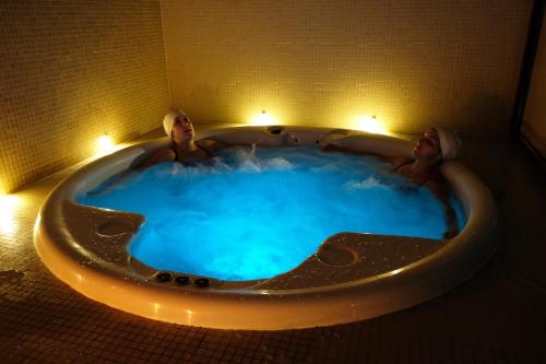 two people in a hot tub in a bathroom at Hotel Da Montanha in Pedrógão Pequeno