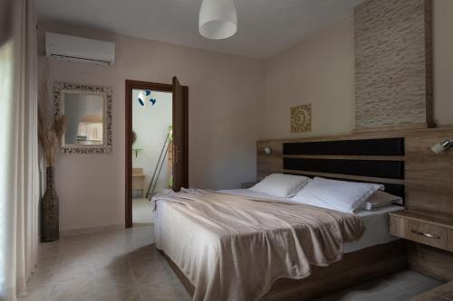 a bedroom with a large bed and a mirror at Tsamakdas House in Toroni