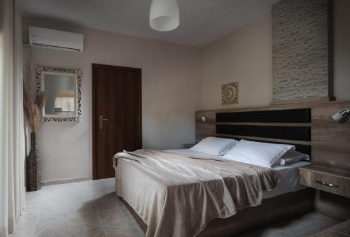 a bedroom with a large bed and a mirror at Tsamakdas House in Toroni
