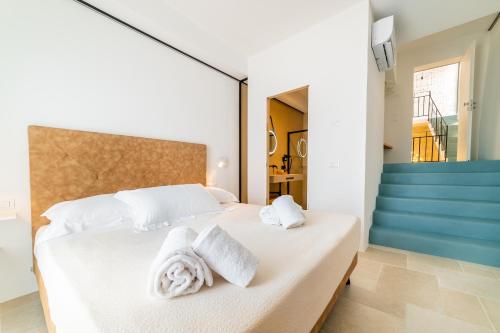 a bedroom with a white bed with towels on it at B&B A C-Caste in Monopoli