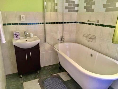 ein Badezimmer mit einem Waschbecken, einer Badewanne und einem Waschbecken in der Unterkunft Beautiful apartment in century city in Kapstadt
