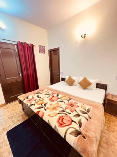a bedroom with a large bed with flowers on it at Residence Inn Homestay in Shimla