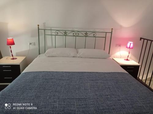 a bedroom with a large bed with two lamps on tables at Casa Angelene in Vitorchiano