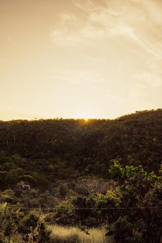 una vista de la puesta de sol desde la cima de una colina en Chalé Brisas en Alto Paraíso de Goiás