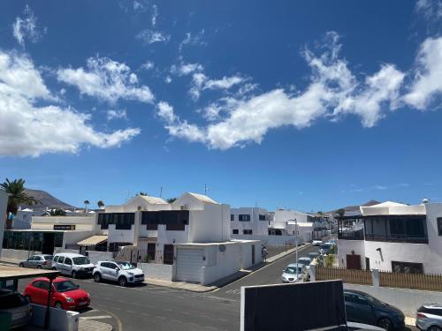 a city street with cars parked in a parking lot at Casa Yurena in Playa Honda