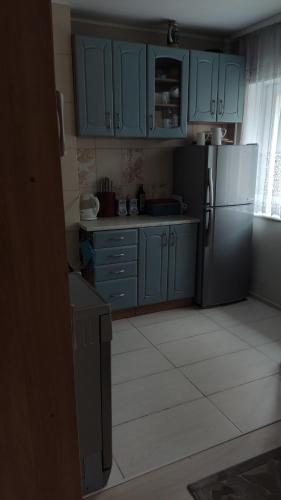 a kitchen with blue cabinets and a refrigerator at Apartament Karłowicza in Gdańsk