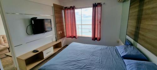 a small bedroom with a bed and a television at Yacht Coast in Fortaleza
