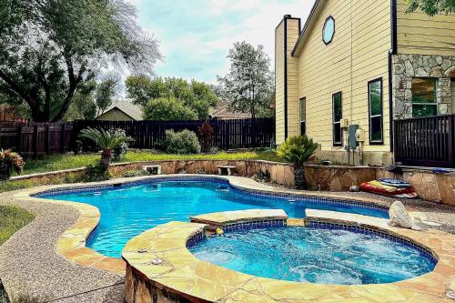 a swimming pool in a yard next to a house at San Antonio Home with Pool and Hot Tub Near SeaWorld! in San Antonio