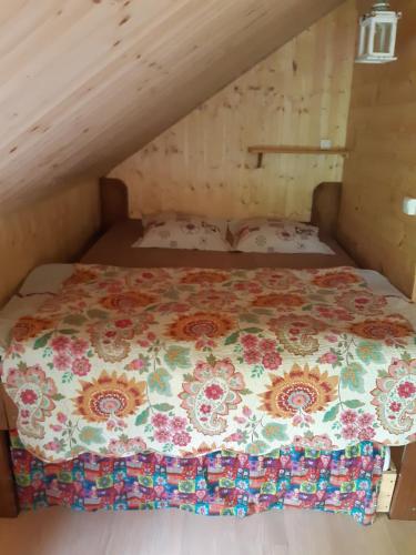 1 dormitorio con 1 cama con colcha de flores en Cabane d'Augustin en Saint-Augustin