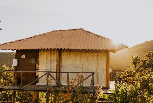 a small hut with a roof on a deck at Chalé Brisas in Alto Paraíso de Goiás