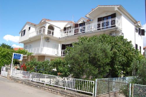 a white house with a fence in front of it at Apartments Bojanic in Vodice