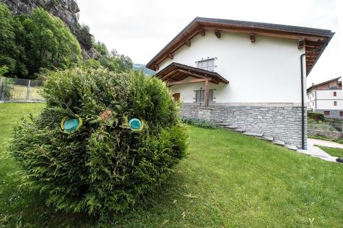 a bush with eyes on it in front of a house at The Green Owl in Antey-Saint-André